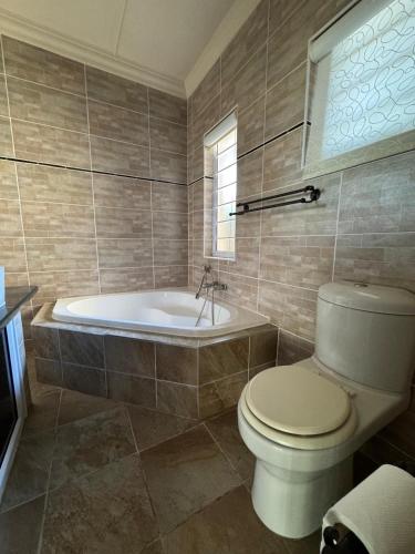 a bathroom with a toilet and a bath tub at 21A on Edgerton in Freeland Park