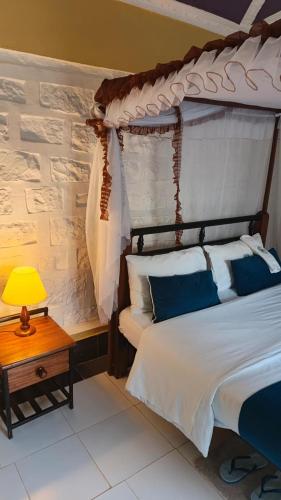 a bedroom with a bed and a table with a lamp at Sandfields Lodwar Resort and Spa in Lodwar