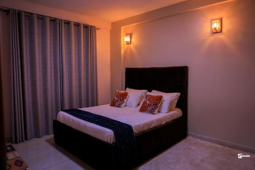 a bedroom with a bed with two pillows on it at Eliana Apartment in Kampala