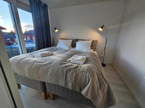 una camera da letto con un letto grande con due asciugamani sopra di Aurora Jukkas Lodge 2 - Arctic Suite a Jukkasjärvi