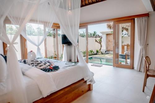 una camera con letto a baldacchino e piscina di NaSya Villa Ubud ad Ubud