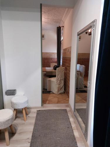 a mirror in a room with a chair and a table at Akácvirág Airport Bogi Apartman in Debrecen