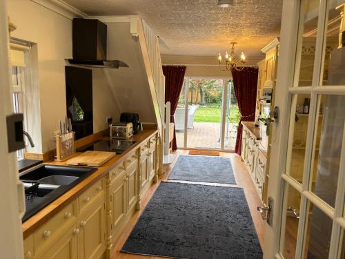 a kitchen with a sink and a counter top at The Corner House, 36, Broadway Road, in Evesham