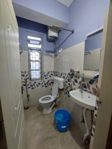 a bathroom with a toilet and a sink at Hotel Rashak - Mg Marg in Gangtok