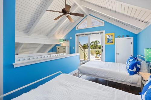 a blue room with two beds and a ceiling fan at SL912: 912 Sealoft in Seabrook Island