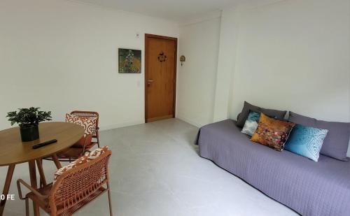a living room with a purple couch and a table at Apartamento Charmoso de 1 quarto em Domingos Martins in Domingos Martins
