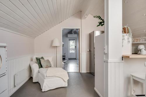 a living room with a white couch and a chair at Loft with lake views in Turku! in Turku