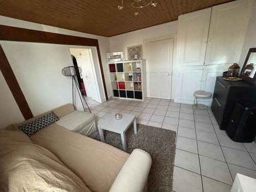 a living room with a couch and a table at Logement entier proche de tout in Bellegarde-sur-Valserine