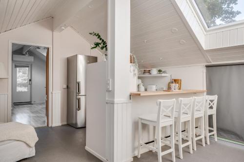a kitchen with a vaulted ceiling and a kitchen island with stools at Loft with lake views in Turku! in Turku