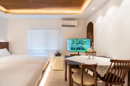 a bedroom with a bed and a table and a tv at 하루재 in Seoul