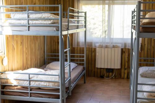 Azay-sur-CherにあるGrand gîte dans un écrin de verdure au bord du Cherの二段ベッド3台と窓のある部屋