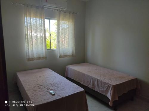 two beds in a room with a window at Casa de Boneca in Prado
