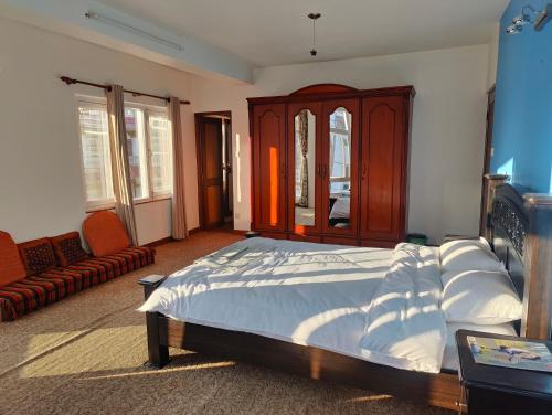 a bedroom with a bed and a cabinet and a couch at Peace Home Apartment Swayambhu in Kathmandu