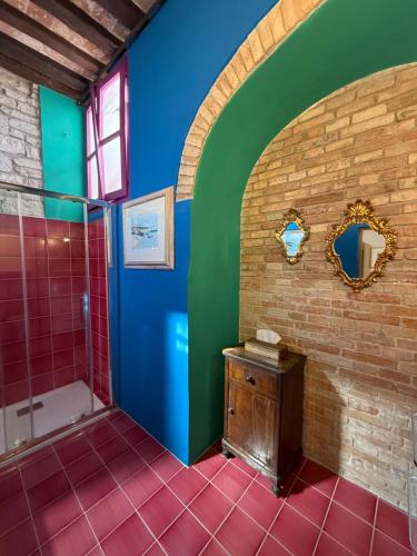 a bathroom with blue and green walls and a shower at Residenza Via Felicchi 10 in Gubbio