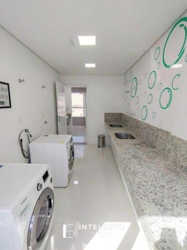 a laundry room with a washer and a washing machine at Living in Poços de Caldas