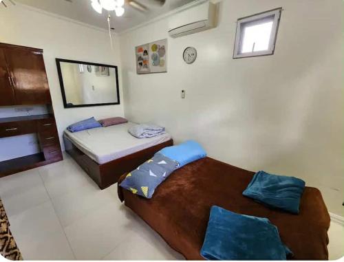 a bedroom with two beds and a mirror at JMC7 Furnished Villa Near Panglao Airport in Panglao