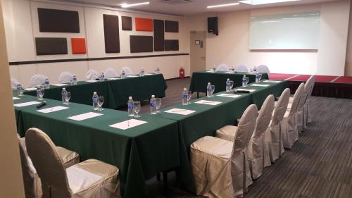 a conference room with green tables and chairs at Bei Boutique Hotel in Muar