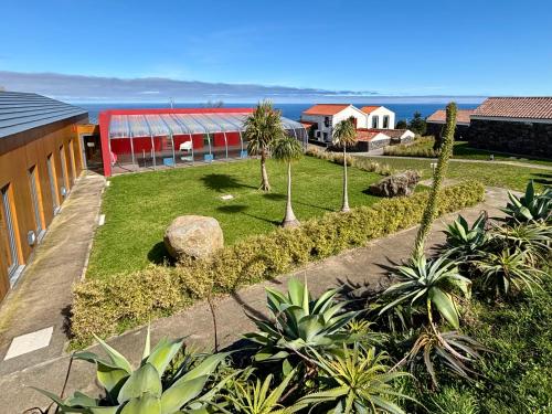 a garden with palm trees and a building at Pátio Ecolodge in Cedros
