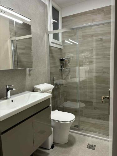 a bathroom with a toilet and a glass shower at Chios Orange Tree Retreat in Chios