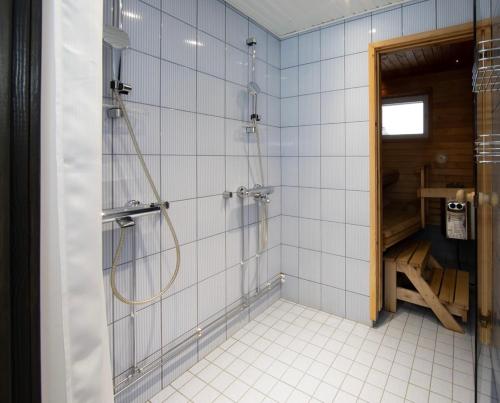 een badkamer met een douche met een glazen deur bij Ski Center Alpine Houses A5 in Levi