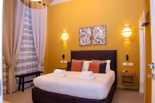 a bedroom with a large bed with yellow walls at Maison Luxury Plaza in Rome