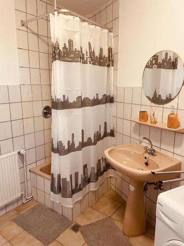 a bathroom with a shower curtain and a sink at Haus Nordwind in Wilhelmshaven