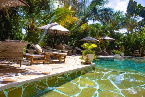a pool with chairs and umbrellas next to a resort at Manaya Luxury Sunset & Serenity Serviced 2Bedroom by Diani Beach with Pool & Parking in Galu