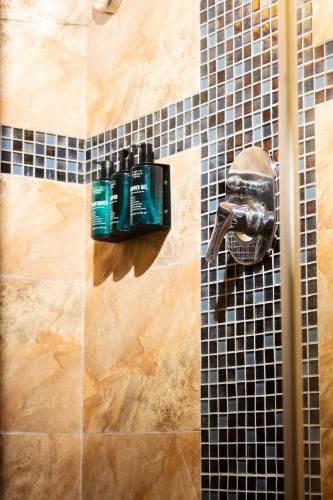 a shower with a soap dispenser on a tiled wall at Manaya Luxury Diani Beach Serviced 2Bedroom with Pool & Parking in Galu
