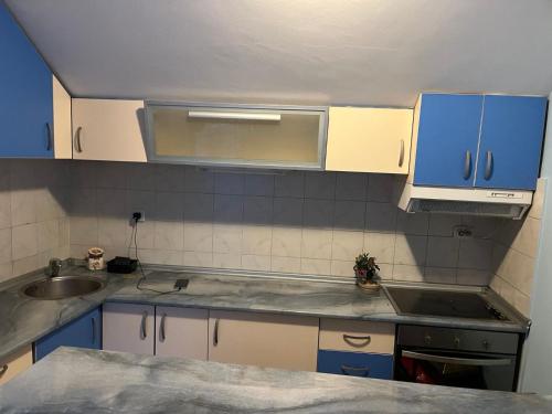 Una cocina con gabinetes azules y un fregadero. en Kraljevacka 13, en Belgrado