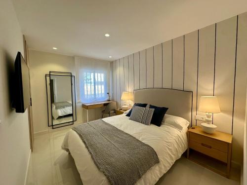 a bedroom with a large bed and a mirror at Picasso 2 Royale in Marbella