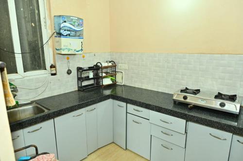 una cocina con fregadero y encimera en JD Homestays, en Jaipur