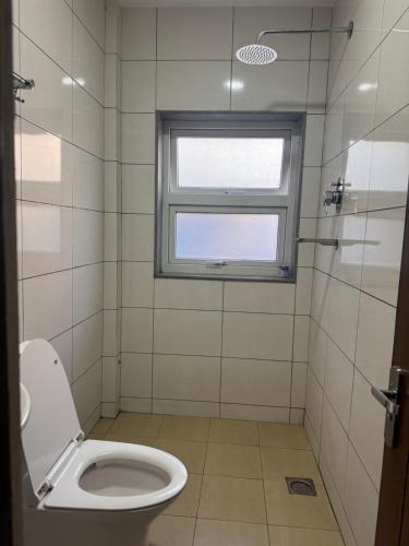 a bathroom with a toilet and a window at My Stay Nepal in Kathmandu