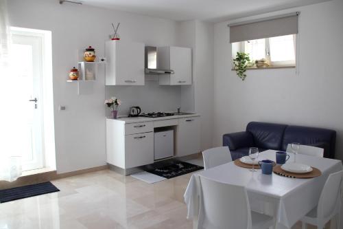un salon avec une table et une cuisine dans l'établissement AuGuStea-The Nest of Sannicandro, à Sannicandro di Bari