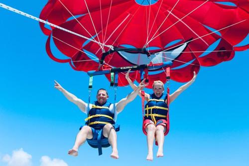 two men in life jackets are riding a parachute at Spacious Studio with Pool access & bathroom kitchen in West Palm Beach in West Palm Beach