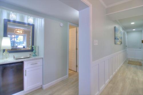 a white bathroom with a sink and a mirror at Tilghman Beach & Racquet Club - 114 in Myrtle Beach