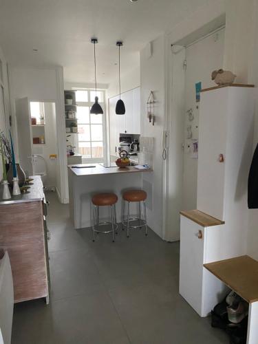 a kitchen with a counter and two stools in it at Appartement partagé -Place Jean Mace in Lyon