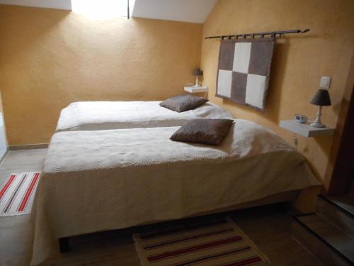 una camera con un letto con due cuscini sopra di Gîte rural Le Falihou (3 épis) a Braives