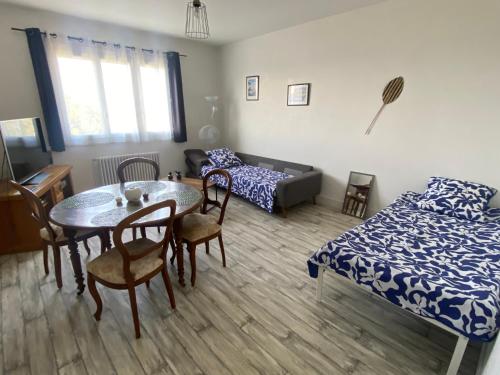 a living room with a table and chairs and a bed at Appartement 4 personnes, 2 ch, parking gratuit et facile in Montceau-les-Mines