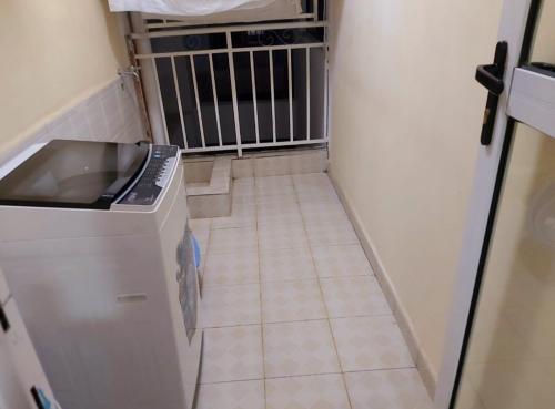 a small kitchen with a sink and a tiled floor at Mango Court in Nairobi