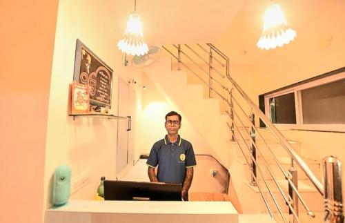 a man standing in front of a laptop in a staircase at Boho BB Villa near Nakki Lake in Mount Ābu