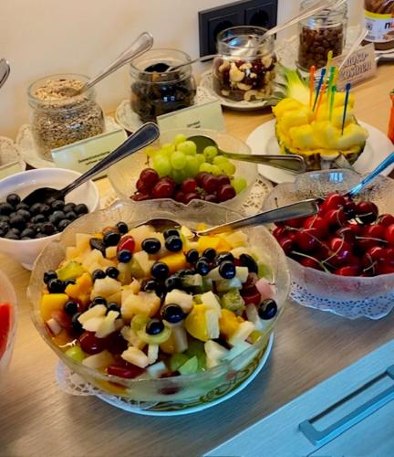 ヴュルツブルクにあるホテル アルター クラネンの果物のボウルと他の食べ物のボウルが置かれたテーブル
