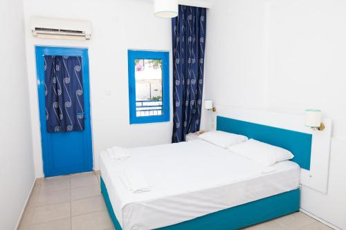 a bed in a room with blue and white walls at One More Day Hotel in Turgutreis