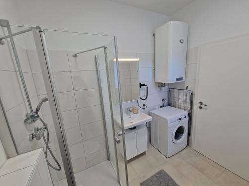 a bathroom with a shower and a washing machine at Mariazell Appartement Kugeltreff in Mariazell