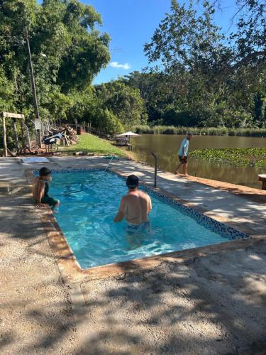 twee mensen in een zwembad naast een meer bij Lago da Rosa in Olímpia