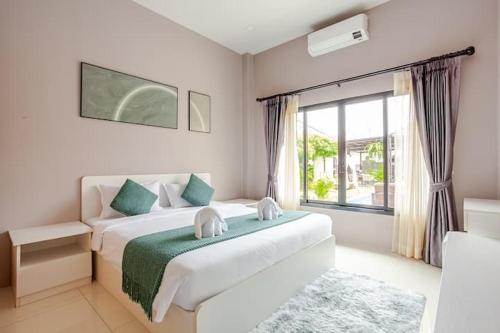 a bedroom with a bed and a large window at 派对家园-11卧室独栋大泳池私密别墅 in Ban Huai Yai