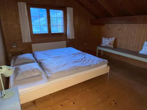 a bedroom with a bed with blue sheets and a window at Helle Ferienwohnung auf BIO-Bauernhof in Grabs