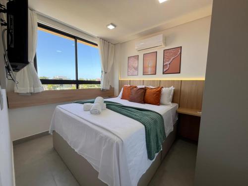 ein Schlafzimmer mit einem großen Bett mit Fenster in der Unterkunft Flat Premium conforto total no centro de Porto de Galinhas, a 4mim a pé das piscinas naturais, praia ! in Porto De Galinhas