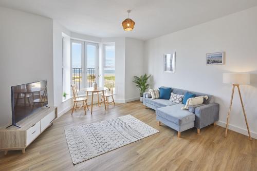 a living room with a couch and a tv at Glenholme Apartments with Sea Views and Balconies in Redcar North Yorkshire in Redcar