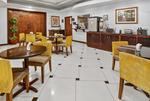 a restaurant with tables and chairs and a kitchen at Robinson Inn and Suites in Robinson