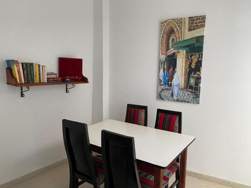 a white table with chairs and a picture on the wall at Dar Saïda Guest house in Tunis
